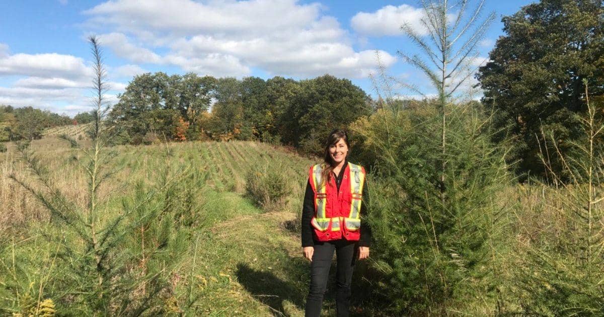 Elizabeth-Celanowicz-stands-beside-a-Larch-tree-planted-in-Caledon-in-2015-as-part-of-the-50-Million-Tree-Program